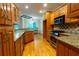Open eat-in kitchen featuring granite countertops, wooden cabinetry, stainless steel appliances, and hardwood floors at 403 Pebblebrooke Ln, Canton, GA 30115