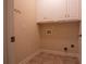 Functional laundry room with tile floor, washer and dryer hookups, and ample overhead cabinet storage at 403 Pebblebrooke Ln, Canton, GA 30115