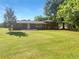 Spacious backyard with lush green grass, mature trees, and a charming brick house at 741 Prince Ave, Marietta, GA 30062