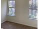 Bedroom featuring two windows offering natural light and carpeted flooring at 6258 Crooked Creek Dr, Rex, GA 30273