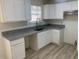 Modern kitchen boasts granite countertops, stainless steel appliances, and white cabinets at 6258 Crooked Creek Dr, Rex, GA 30273