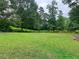 Large grassy backyard with mature trees and privacy fence at 4132 Scenic Mountain Dr, Snellville, GA 30039