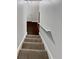 Carpeted stairway leading to a landing with dark wood floors and a white door at 1575 Ridenour Nw Pkwy # 804, Kennesaw, GA 30152
