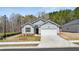 Charming single-story home featuring a two-car garage, stone accents, and manicured lawn at 8588 Preakness Pass, Lithonia, GA 30058
