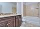 Bathroom with brown cabinets, granite countertops, a toilet, and a tiled tub and shower at 6198 Ripple Way # 87, South Fulton, GA 30349