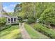 Lush backyard with a gravel pathway, healthy green lawn, and white picket fence surrounded by mature trees at 4055 Vinings Mill Se Trl, Smyrna, GA 30080