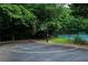 Community basketball court surrounded by trees with court lines and a partial view of the tennis court at 4055 Vinings Mill Se Trl, Smyrna, GA 30080