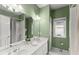Bright bathroom with double sinks, a shower with curtains, and green walls at 4055 Vinings Mill Se Trl, Smyrna, GA 30080