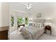 Bright bedroom featuring a ceiling fan, neutral walls, and large windows with views of the surrounding greenery at 4055 Vinings Mill Se Trl, Smyrna, GA 30080