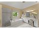 Bright main bathroom featuring a soaking tub, shower, vanity with makeup area, and natural light at 4055 Vinings Mill Se Trl, Smyrna, GA 30080