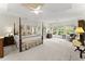 Spacious main bedroom featuring a four-poster bed, tray ceiling, and large windows with outdoor views at 4055 Vinings Mill Se Trl, Smyrna, GA 30080