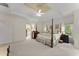 Spacious main bedroom featuring a four-poster bed, a glimpse of the en-suite bathroom, and tray ceiling at 4055 Vinings Mill Se Trl, Smyrna, GA 30080