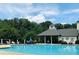 Community pool featuring a covered area, lounge chairs, and a backdrop of lush greenery at 4055 Vinings Mill Se Trl, Smyrna, GA 30080