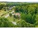 Aerial view of the property, showcasing lush trees, the home's roof, driveway, and surrounding neighborhood at 52 Olivia Ct, Palmetto, GA 30268