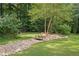Picturesque backyard featuring a small wooden bridge over a rocky stream and lush landscaping at 52 Olivia Ct, Palmetto, GA 30268