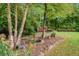 Scenic backyard features a fire pit, a trellis with seating, a pond and lush landscaping and mature trees at 52 Olivia Ct, Palmetto, GA 30268