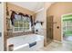 Bathroom featuring a bathtub, large window, and tiled shower at 52 Olivia Ct, Palmetto, GA 30268