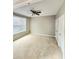 Spacious bedroom boasts a ceiling fan, a large window, carpeted flooring, and double closets at 52 Olivia Ct, Palmetto, GA 30268