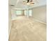 Spacious bedroom featuring tray ceiling, fan, and large windows at 52 Olivia Ct, Palmetto, GA 30268
