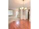Dining room features hardwood floors, a chandelier, and a view of the adjacent living area and staircase at 52 Olivia Ct, Palmetto, GA 30268