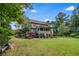 Lush green lawn showcasing a multi-story home with a deck, porch, patio, and mature trees at 52 Olivia Ct, Palmetto, GA 30268
