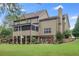 Back exterior of a multi-story home with a screened-in porch, deck, patio, and landscaped yard at 52 Olivia Ct, Palmetto, GA 30268