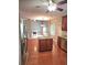 Bright kitchen features wood floors, center island, stainless appliances, open concept, and a view of the fireplace at 52 Olivia Ct, Palmetto, GA 30268