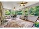Screened-in porch featuring a ceiling fan, comfortable seating, a leaf-pattern rug, and lush green views at 52 Olivia Ct, Palmetto, GA 30268