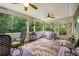 Charming screened-in porch features a ceiling fan, comfortable seating, a rug and views of the surrounding greenery at 52 Olivia Ct, Palmetto, GA 30268