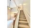 Carpeted stairs with wood railing lead from the living area to the upper floors, bathed in natural light at 52 Olivia Ct, Palmetto, GA 30268