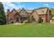 Elegant brick and stone home with manicured lawn and mature landscaping offers luxurious curb appeal at 2145 Jones Phillips Rd, Dacula, GA 30019
