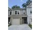 Charming two-story townhome featuring a one-car garage and neutral-tone siding with stone accents at 6202 Ripple Way # 88, South Fulton, GA 30349