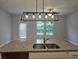 Kitchen island featuring granite counters, a sink, and a pendant light fixture, plus a view of the backyard at 6202 Ripple Way # 88, South Fulton, GA 30349