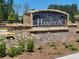 Stone and brick community sign for Oakchase at Hampton with flower garden at 126 Oakchase Park Ln, Hampton, GA 30228