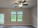 Bright living area showcases a ceiling fan, two windows, and a glass door for outdoor access at 6206 Ripple Way # 89, South Fulton, GA 30349