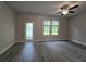 Bright living area showcases a ceiling fan, two windows, and a glass door for outdoor access at 6206 Ripple Way # 89, South Fulton, GA 30349