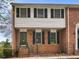 Charming brick townhome with black shutters, a glass front door, and a small landscaped yard at 6520 Roswell Rd # 59, Atlanta, GA 30328