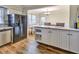 Open kitchen featuring wood floors, white cabinets, stainless steel dishwasher, and eat-in dining space at 6520 Roswell Rd # 59, Atlanta, GA 30328
