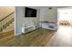Living room featuring hardwood floors, stairs, a large TV, and access to the dining area at 6520 Roswell Rd # 59, Atlanta, GA 30328