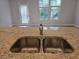 Island with a double sink and granite countertops, with a view to a door and windows at 6214 Ripple Way # 91, South Fulton, GA 30349