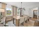 Modern dining room with a wooden table, neutral decor, and large windows at 6076 Marigold Way, Atlanta, GA 30349