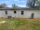 View of the backyard with well-maintained lawn, AC unit, and white brick at 1909 Meadow Ln, Decatur, GA 30032