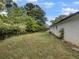 Spacious backyard showing the side of the house with a white brick exterior and a lush green lawn with trees at 1909 Meadow Ln, Decatur, GA 30032