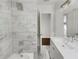 Bathroom featuring a tiled shower with a rain shower head, a vanity with modern fixtures, and a door to another room at 1909 Meadow Ln, Decatur, GA 30032