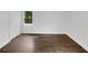 A bright empty bedroom features light walls and new dark wood flooring at 1909 Meadow Ln, Decatur, GA 30032