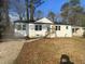 Charming single-story home with a white brick exterior, a front porch, and a well-manicured lawn and driveway at 1909 Meadow Ln, Decatur, GA 30032