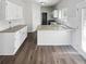 Well-lit kitchen with ample counter space, wooden floors, stainless steel appliances, and white cabinetry at 6235 Marbut Farms Trl, Lithonia, GA 30058