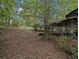 Backyard featuring a lush, sloped lawn with a covered patio and wooded perimeter at 2497 Mobley Se Ct, Atlanta, GA 30315