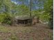 View of home's backyard, showing a brick structure and wooded surroundings at 2497 Mobley Se Ct, Atlanta, GA 30315