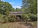 View of home's overgrown backyard, showing plants and wooded surroundings at 2497 Mobley Se Ct, Atlanta, GA 30315